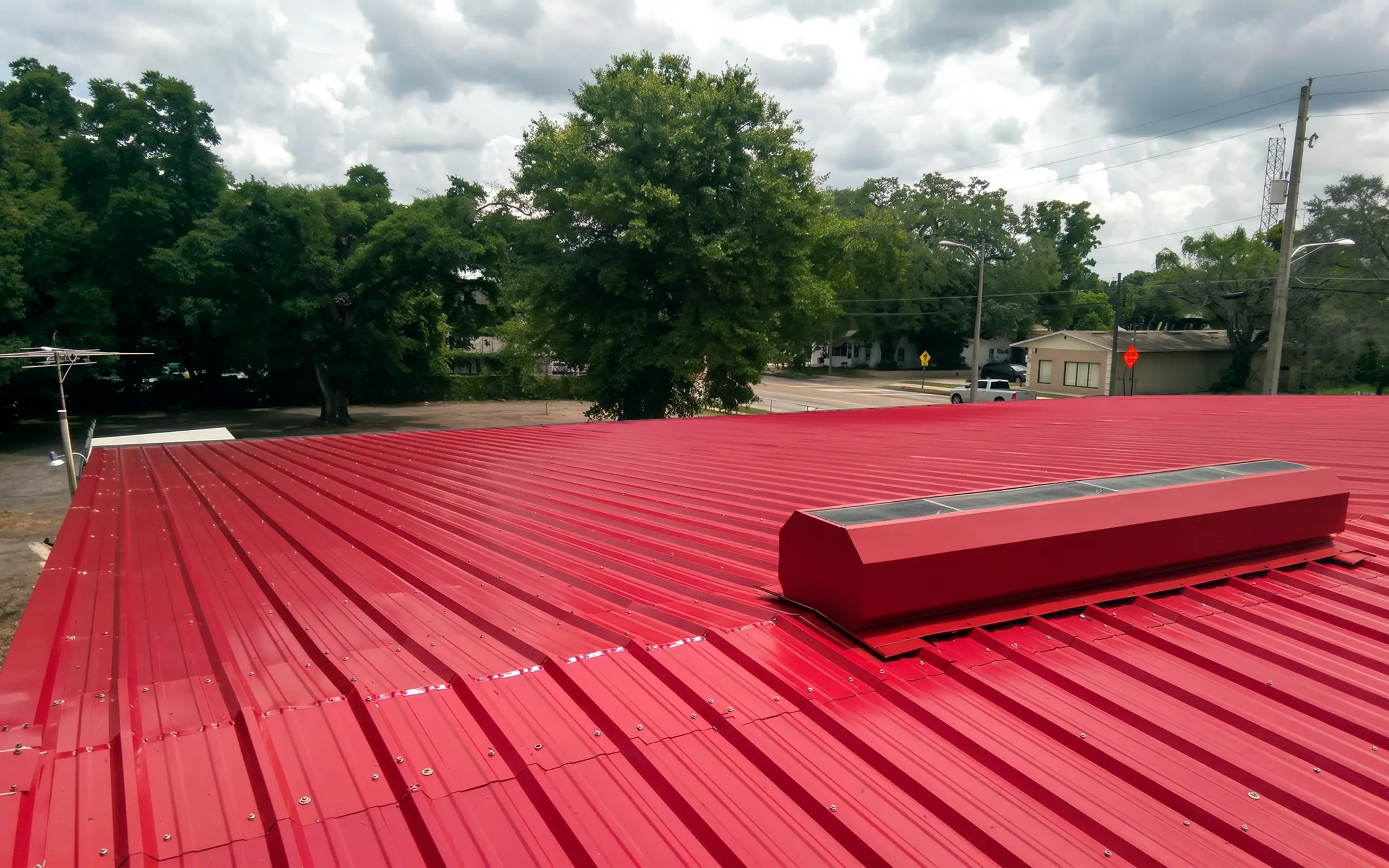 Finished red standing-seam metal roof on a commercial building in Deltona.